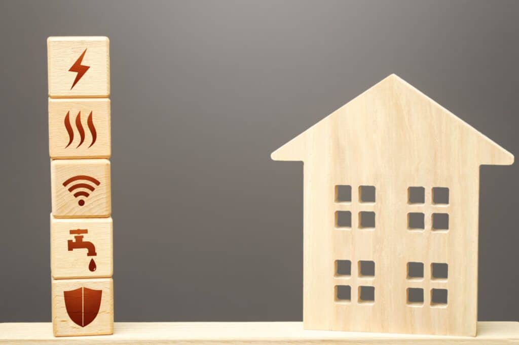 A house figurine and blocks with utility icons