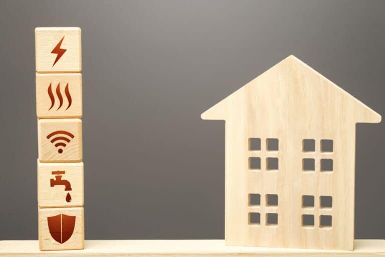 A house figurine and blocks with utility icons