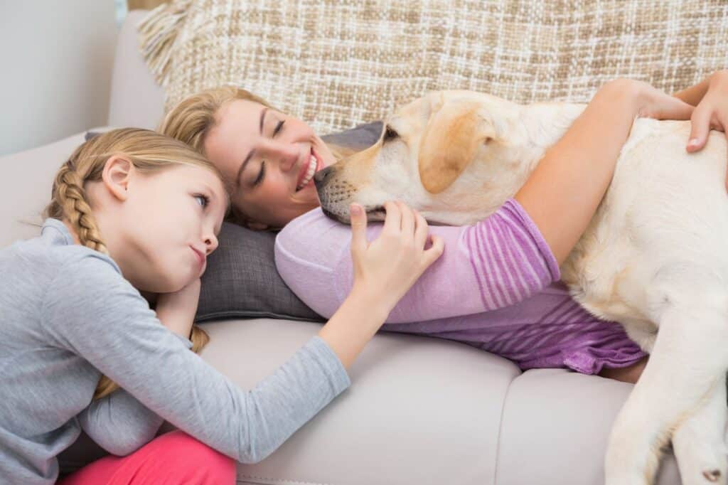 A mother, daughter and pet dog on the living room