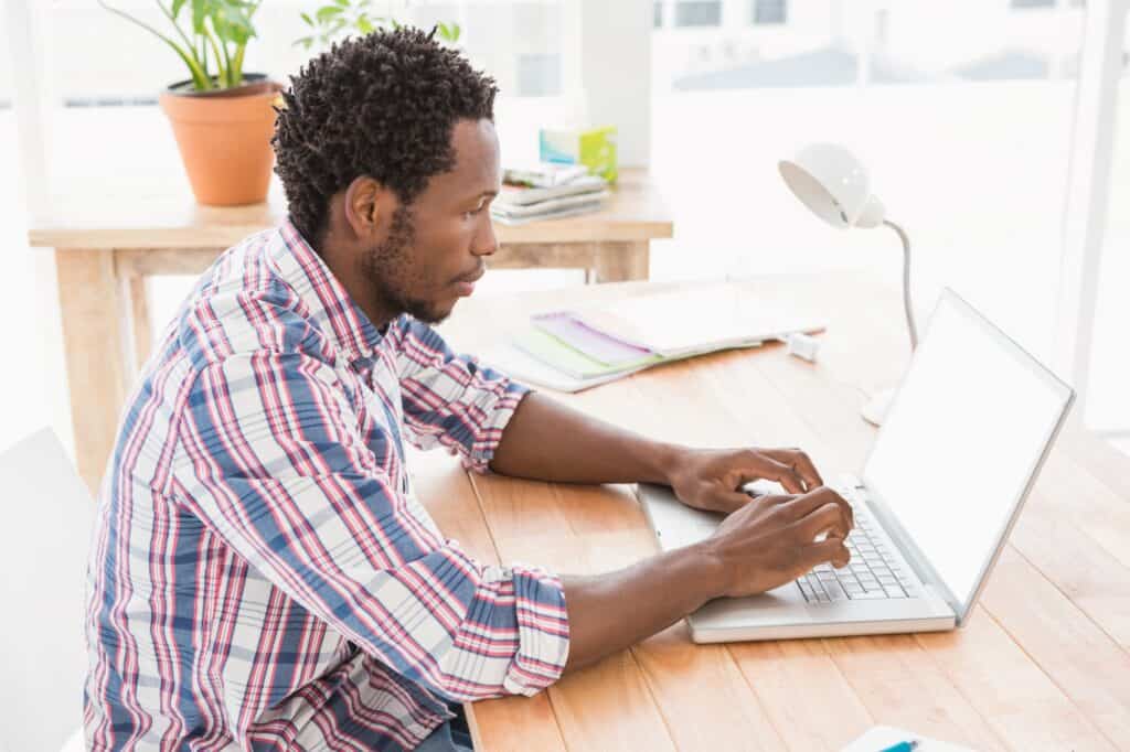 A young man in front of his laptop, communicating with a professional Man and Van