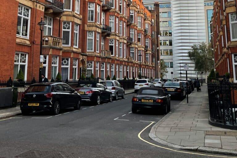 Terraced houses with parked cars on the street in the concept of 'best affordable housing in Ilford'.