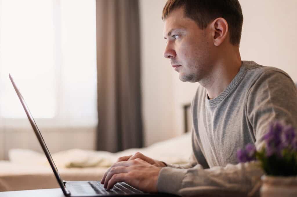 A man in front of the computer researching for Man and Van in Ilford