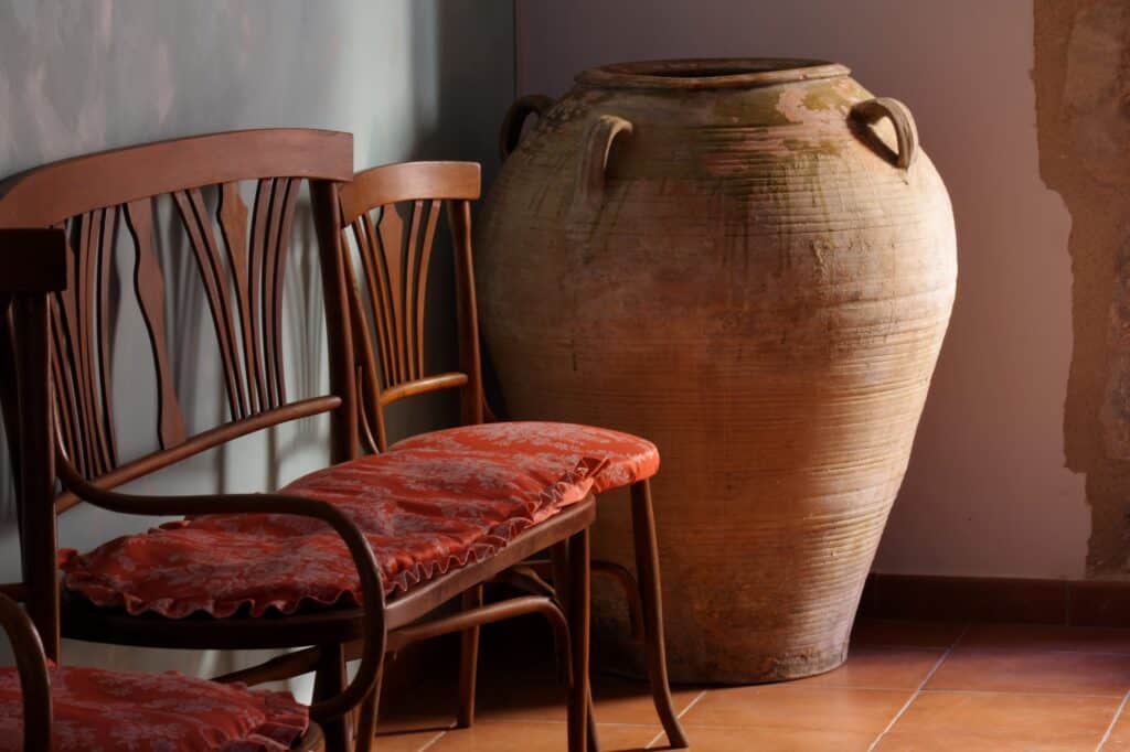 Old chairs and a huge jar in the corner of the room